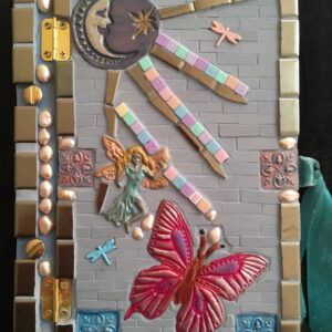 Image of a mosaic book cover featuring ceramic tile, polymer clay pieces and found objects.