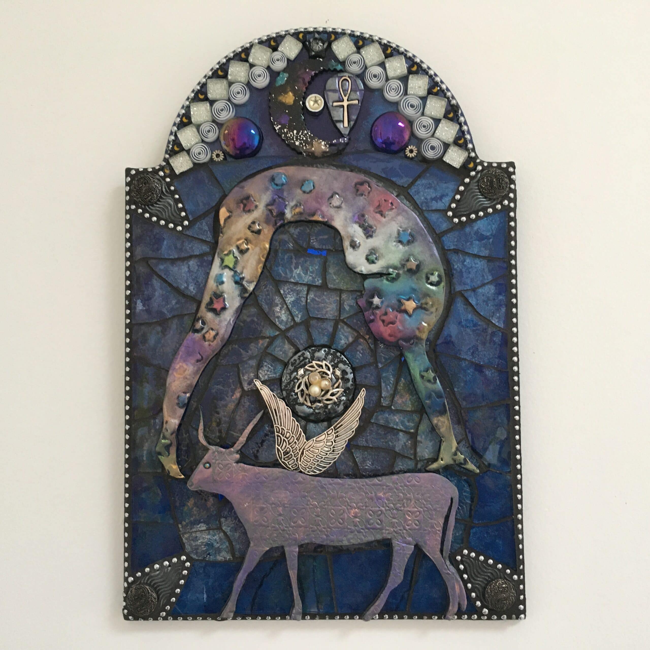 A mixed media mosaic featuring the side profile of a nude female figure bent across the sky with a large horned and winged cow beneath her.