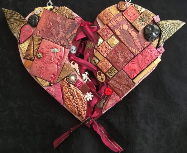 Image of a heart-shaped mixed media work featuring polymer clay pieces and found objects.